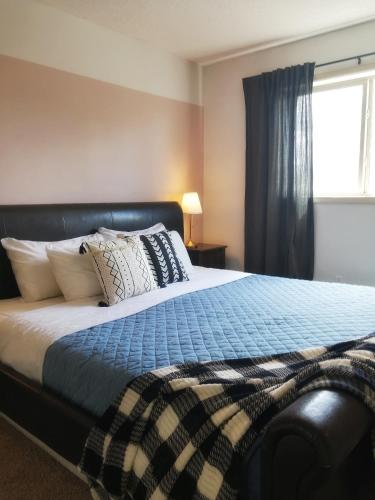 镭温泉Bright 3 bed 3 bath House in Radium Hot Springs的卧室配有带枕头的床铺和窗户。