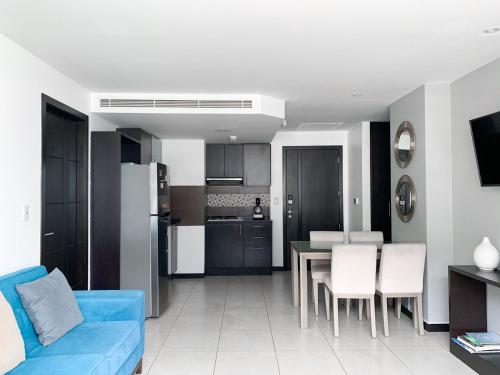 瓜亚基尔Penthouse de 2 habitaciones con vista al rio y parking的一间带蓝色沙发的客厅和一间厨房