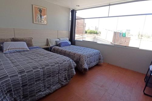 阿雷基帕Depa de Estreno en Arequipa的酒店客房设有两张床和大窗户。