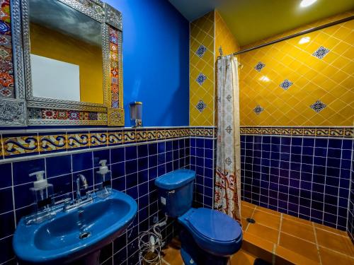 罗萨里托Hotel Cantaritos的浴室设有蓝色的卫生间和水槽。