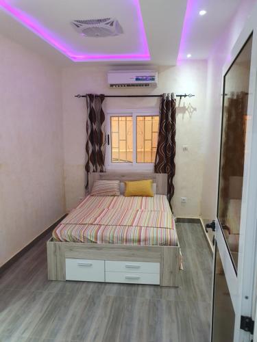 巴马科Villa meuble golf的一张位于带紫色天花板的小房间内的床铺