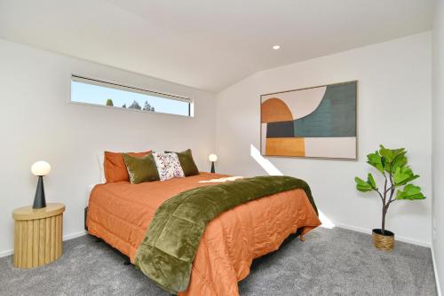 基督城Chatham Street - Christchurch Holiday Homes的一间卧室配有一张带橙色床罩的床