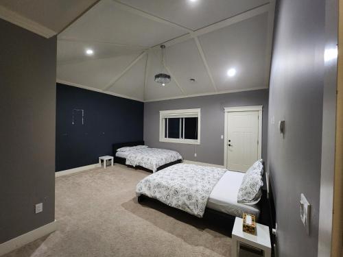 萨里Harmony Hospitality "Walking Distance to Surrey Central"的一间卧室设有两张床,拥有蓝色的墙壁。