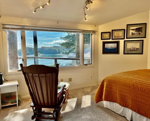 科迪亚克The Captains View - Cliffside, Ocean Views的卧室配有床、椅子和窗户。