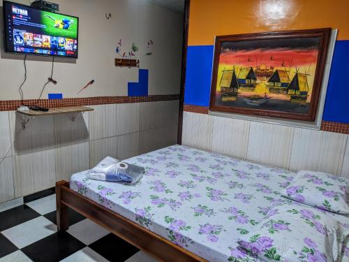 里奥普雷托达伊娃Pousada Aguiar的一间设有床铺和电视的房间