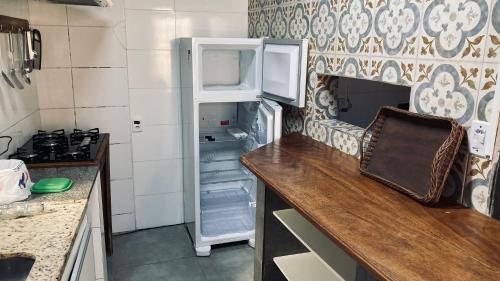 弗洛里亚诺波利斯Vila Verde casa com ar condicionado e vista da lagoa的厨房设有开放式冰箱,门是敞开的。