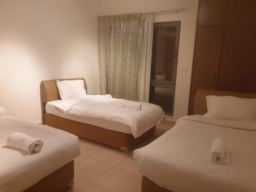 亚喀巴Flat Luxury 2 bed rooms apartment talabay aqaba的酒店客房设有两张床和窗户。