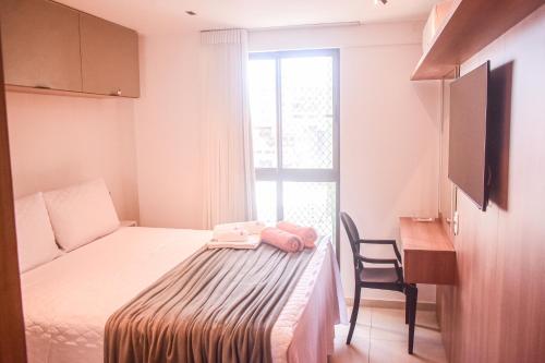 若昂佩索阿Ecotambaú, Espetacular Flat Com Piscina ao Lado da Praia的一间卧室配有一张床、一张书桌和一个窗户。