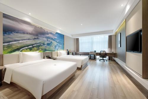 南宁南宁南湖地铁站亚朵酒店 的酒店客房设有两张床和一台平面电视。