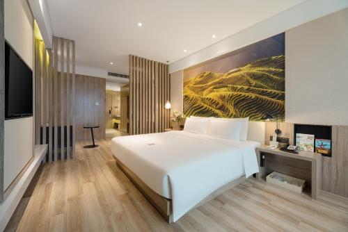 南宁南宁南湖地铁站亚朵酒店 的卧室配有一张白色大床和一幅画