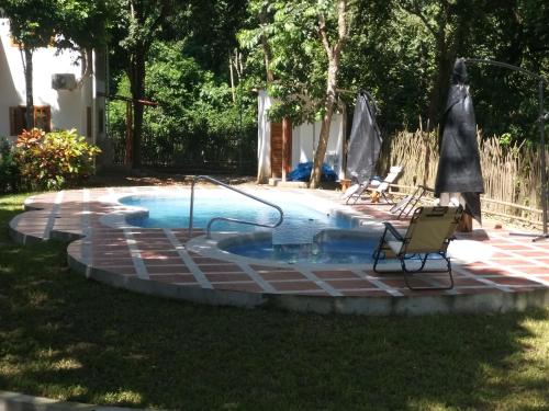Las TunasNueva Tierra的院子里的游泳池旁边设有两把椅子
