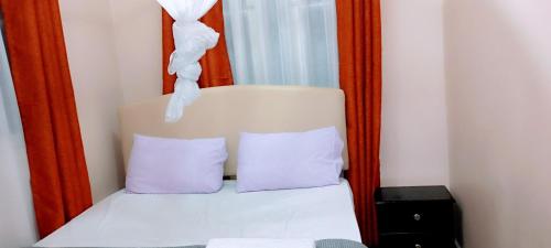 基苏木Comfort Inn的一张带两个紫色枕头的床铺,位于镜子前