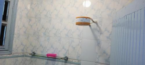基苏木Comfort Inn的白色瓷砖浴室的墙壁上配有肥皂机