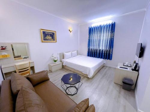 河仙Sai Gon Ha Tien Hotel的客厅配有沙发和1张床