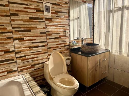拉巴斯Hotel Esmeralda的一间带卫生间和木墙的浴室