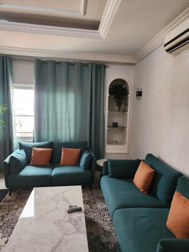 布拉柴维尔appartement nid的客厅配有2张蓝色的沙发和1张桌子