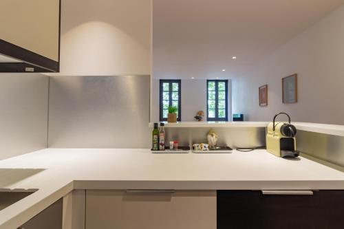 图卢兹404 · Wonder Appart - Vue Garonne -的厨房配有白色的柜台和水槽