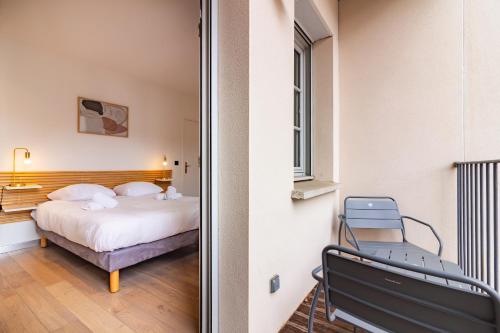图卢兹404 · Wonder Appart - Vue Garonne -的一间卧室,卧室内配有一张床和一把椅子