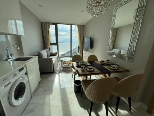 乔木提恩海滩Copacabana Jomtien Beach Condo 中天海滩寇芭酒店公寓的厨房以及带洗衣机的起居室。