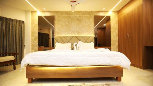 甘吉布勒姆Hotel TamilNadu, Kancheepuram的一间卧室设有一张大床和一个大镜子