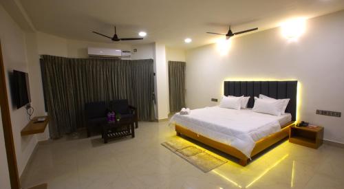 甘吉布勒姆Hotel TamilNadu, Kancheepuram的卧室配有一张白色大床和一把椅子