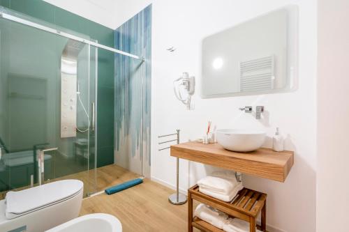 莫诺波利Casa Del Barone - Luxury Suites的一间带水槽和玻璃淋浴的浴室