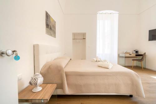 莫诺波利Casa Del Barone - Luxury Suites的白色卧室配有床和桌子
