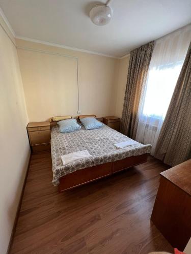 巴尔喀什4-местные домики的一间卧室设有一张床和一个窗口