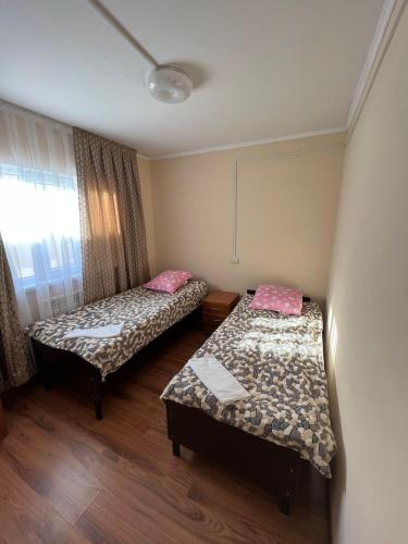 巴尔喀什4-местные домики的客房设有两张床和窗户。