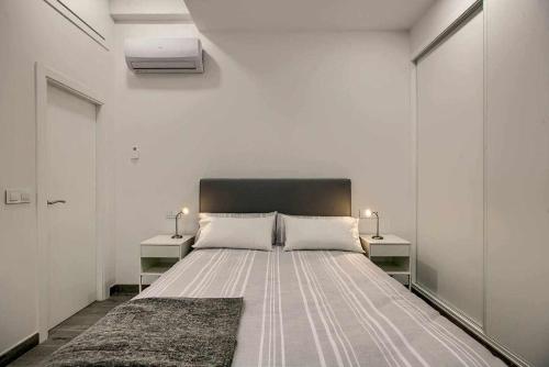马德里RiNa MADRID apartamento 2的一间卧室配有一张带2个床头柜的大床