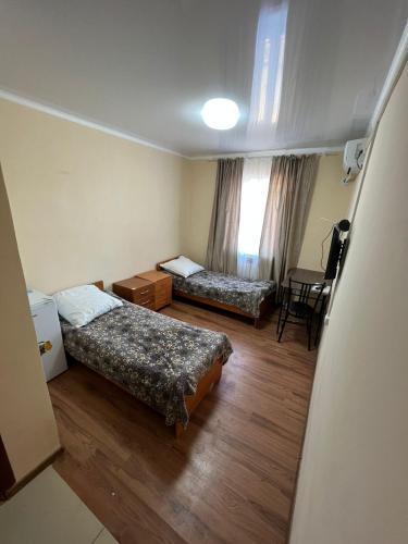 巴尔喀什Гостиница Набережная的一间设有两张床和一张桌子的房间