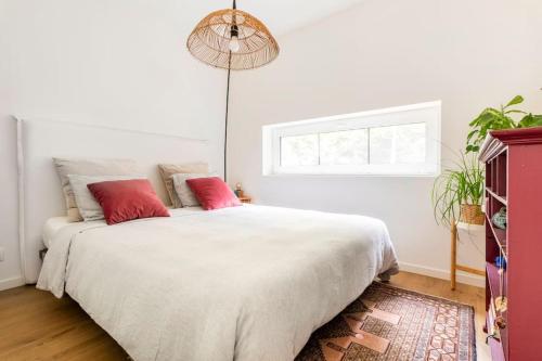 StekeneLuxe-Avontuur in een Romantische Cabin in het Bos的卧室配有带红色枕头的大型白色床