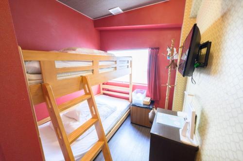 广岛Hiroshima Wabisabi hostel 広島ワビサビ ホステル的客房设有两张双层床和电视。