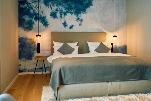 Sankt JohannHofgut Wißberg - Das Weinberghotel的卧室配有一张大床,墙上挂有绘画作品