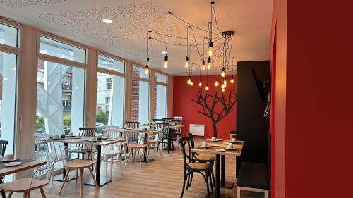 亚眠Nemea Appart Hotel Coliseum Amiens Centre的用餐室设有桌椅和窗户。