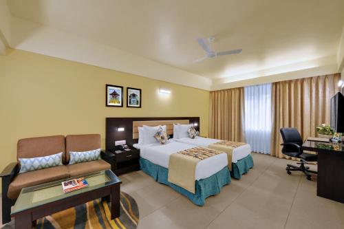 VernaThe Fern Kesarval Hotel & Spa, Verna Plateau - Goa的酒店客房,配有床和沙发