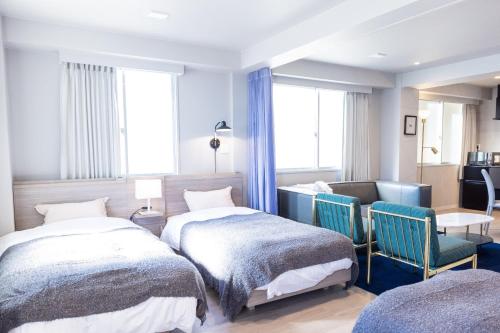 高知RESIDENCE HARIMAYA-Vacation STAY 99863v的一间卧室配有两张床和一张桌子及椅子