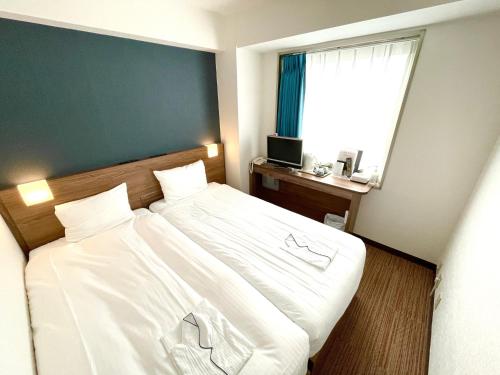 东京东京良日酒店的卧室配有一张大白色床和窗户
