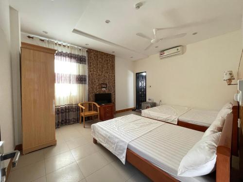 洞海Thăng Long Hotel的酒店客房设有两张床和电视。