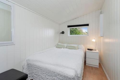 ÅrøyFeriehus nær badeplass og Molde sentrum的一间白色的小卧室,配有床和窗户