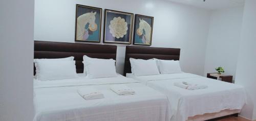巴纳韦TAM-AN HOTEL BANAUE的配有白色床单的酒店客房内的两张床