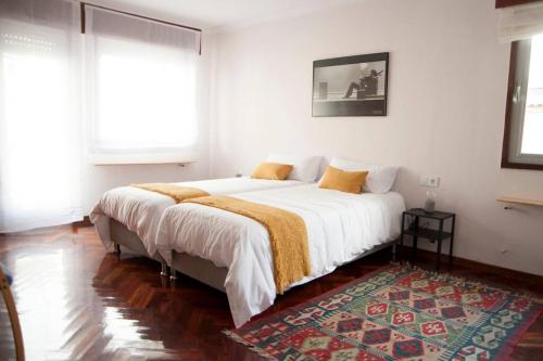 维戈Casa amplia, confortable, céntrica by Prishomes的一间卧室配有一张带白色床单和地毯的床。