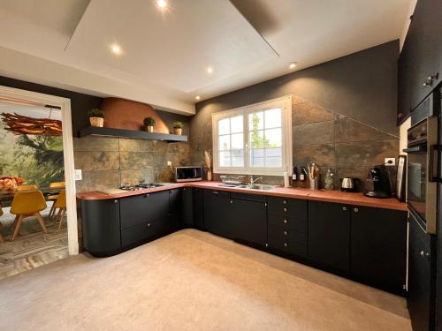 圣法戈蓬蒂埃里PikBeach77的厨房配有黑色橱柜和窗户。