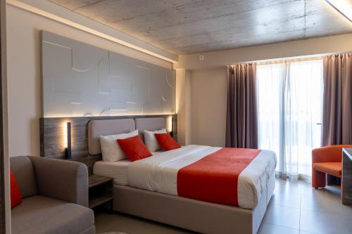 埃尔哥茨拉Alavits Hotel by ST Hotels的一间卧室配有一张床、一张沙发和一把椅子