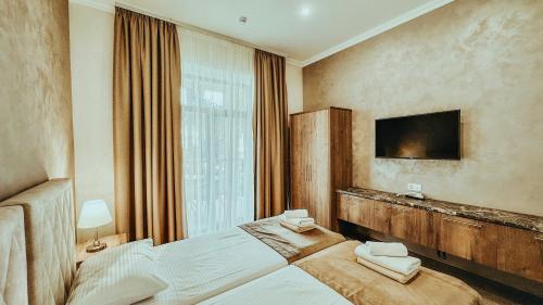 加格拉Парк СПА Отель Нарт的卧室配有一张床,墙上配有电视。