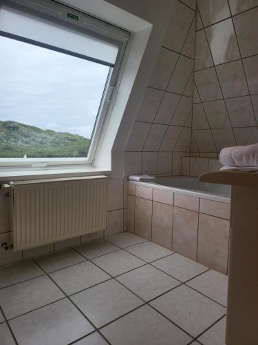 韦斯特兰Villa am Meer的一间带大窗户和浴缸的浴室