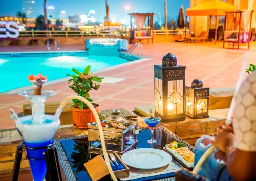 开罗拉姆西斯希尔顿酒店&赌场的一张桌子,旁边是游泳池,摆放着食物和饮料