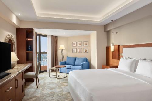开罗拉姆西斯希尔顿酒店&赌场的酒店客房,配有一张床和一张蓝色椅子