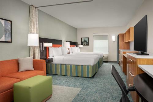 圆石城朗德罗克奥斯汀希尔顿欣庭套房酒店的酒店客房,配有床和沙发