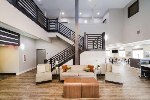 休斯顿霍比北速8酒店的客厅设有楼梯、沙发和椅子